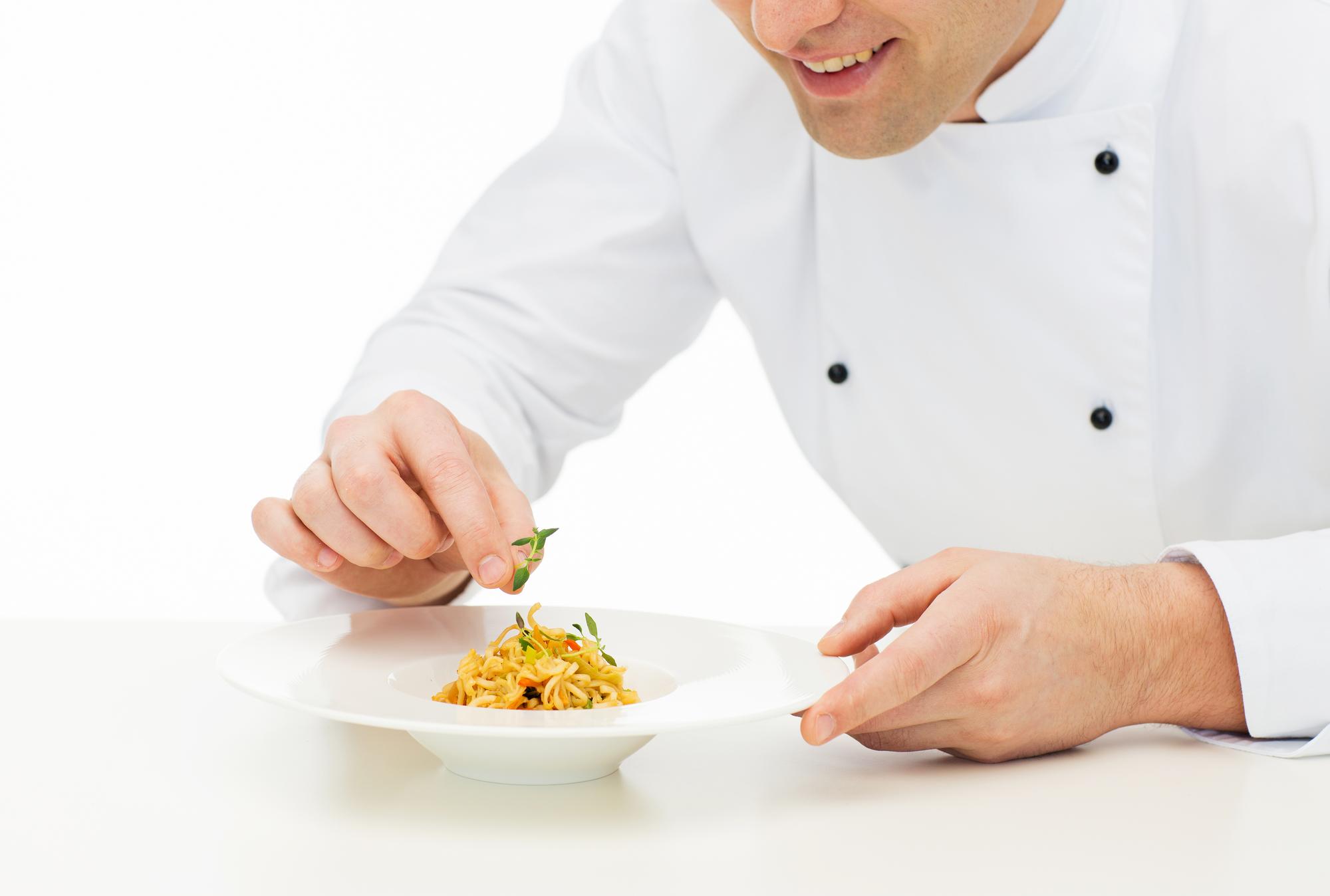 Instructor plating a quick pasta dish on a modern kitchen counter